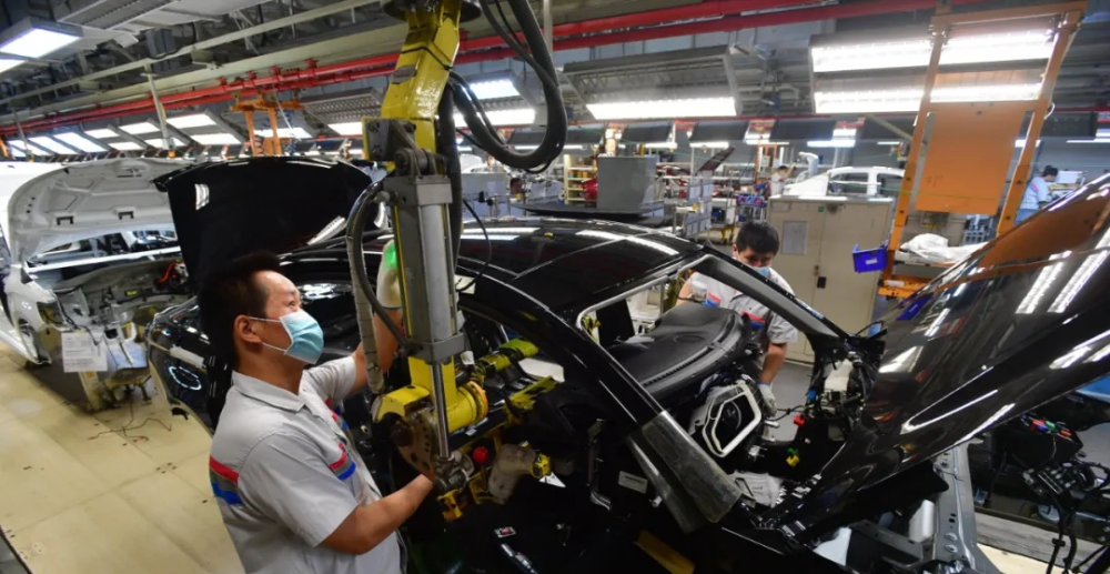 神龙三厂总装车间,工人正在安装仪表总成.