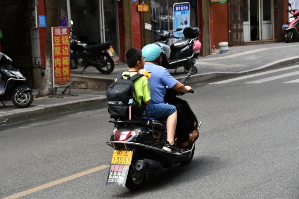 台山小学 驾乘电动车的家长及学生 头盔佩戴率较高.