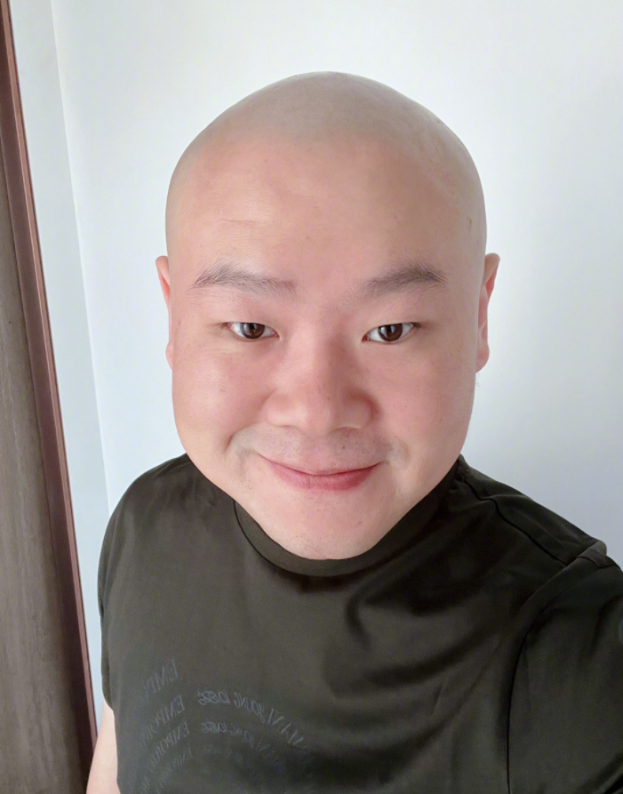 头发胡茬剃得干干净净,脑袋圆润抿嘴笑太喜庆