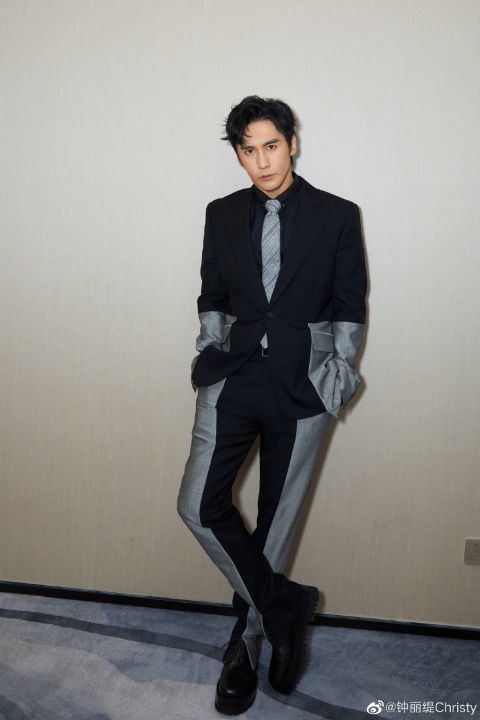 身穿黑色皮质套装,与身穿黑灰拼接西装的老公张伦硕站在一起拍照十分