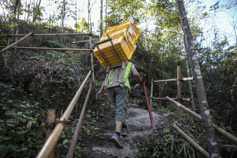 暴雨阻断进山路物流司机肩挑背扛送希望上山