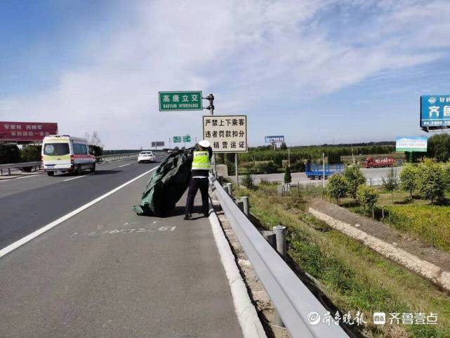 青银高速上大块塑料布随风翻滚,巡逻交警及时清除隐患
