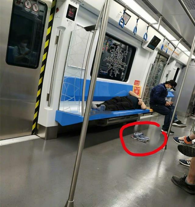 北京一男子地铁脱鞋霸座睡觉,有人趁他睡着,将他一只鞋踢出车外