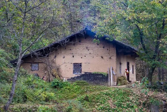 小河沟旁的一栋老房子,冒着一点点若有若无的炊烟,房子后面是绵延不断