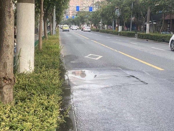 这段道路坑洼积水车辆驶过容易溅湿路人