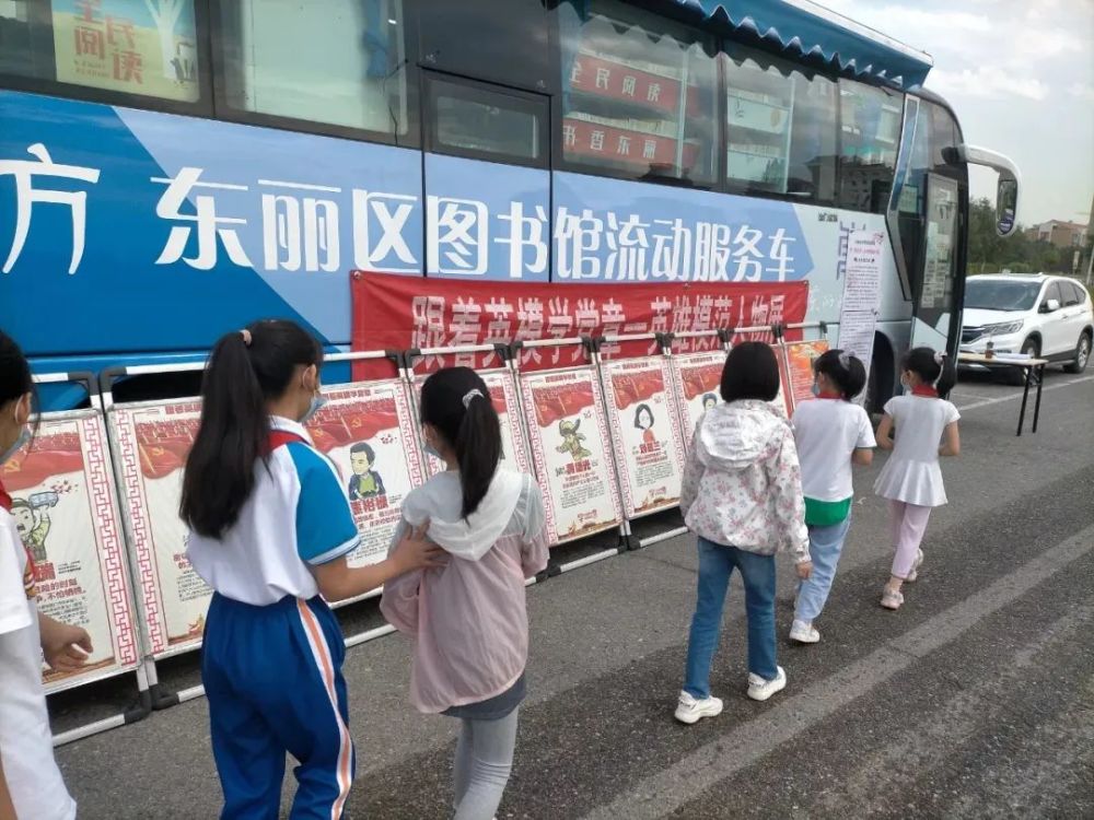 辖区内的居民,青少年在流动图书车上翻阅各自喜欢的书籍,许多居民为了