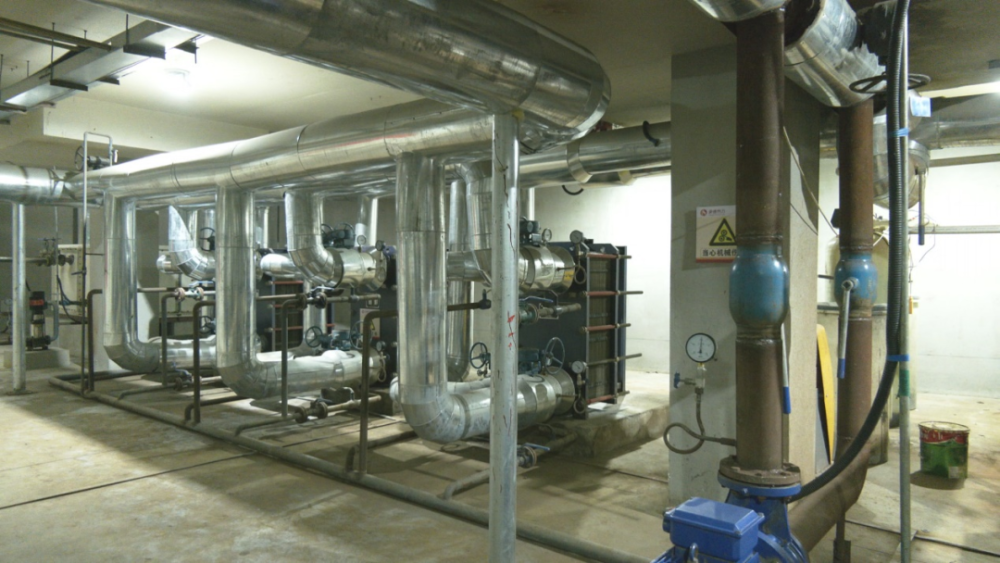 小区换热站,供热公司工作人员正在对站内的循环泵,加压泵和补水泵巡检