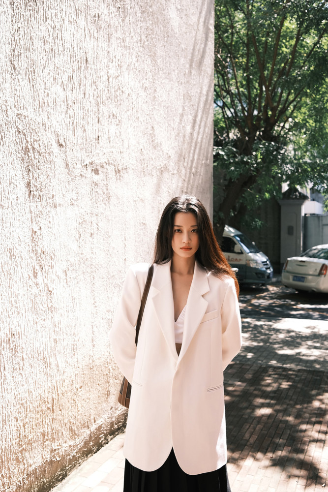 大片中,孙佳雨置身于秋日暖阳下,身穿白西装搭配黑裙,慵懒优雅,整体穿