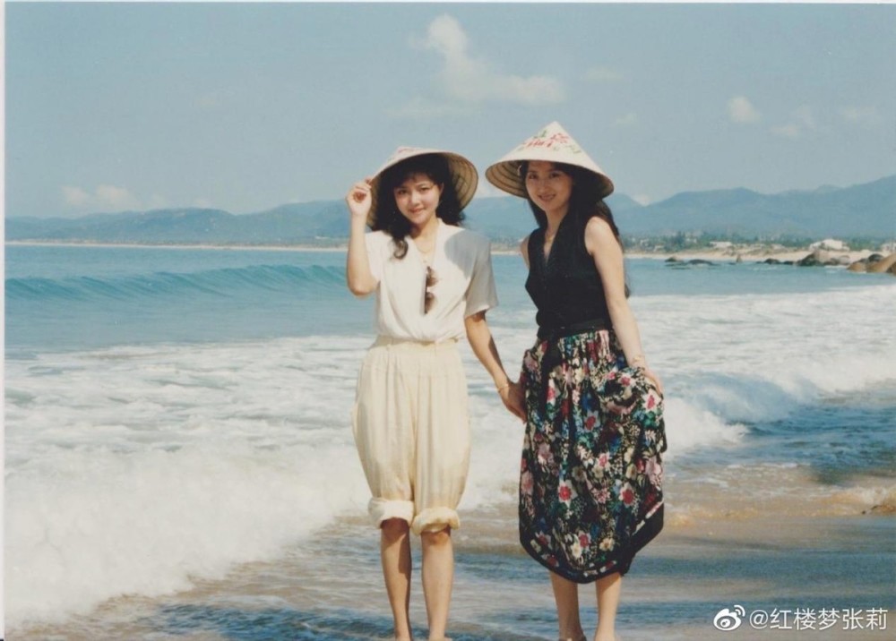 海边合影,张莉穿着白衣服,长裤挽起来露出纤细小腿,陈晓旭穿着无袖黑