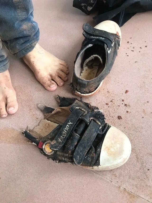 穿着一双破损的鞋走在楼梯上,该校3年级学生小明(化名)下着淅淅沥沥的