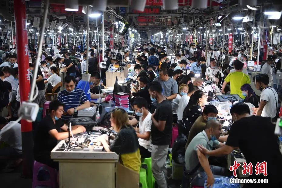 瑞丽市德龙珠宝夜市上,一位买家在一名缅甸商人的摊位查看石头.
