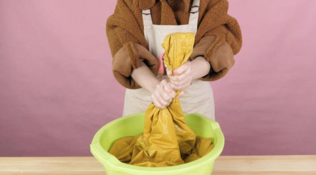 第五步 :接下来就是拧干水分了,用手挤压羽绒服,把水推出来,注意不要