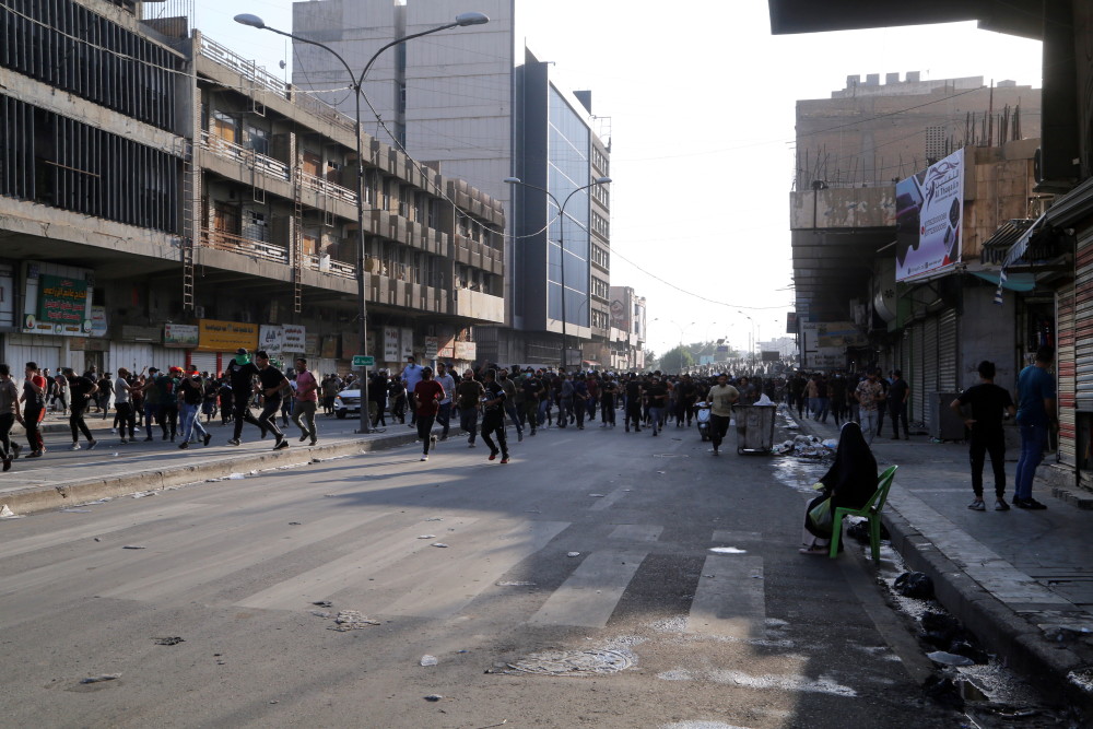 11月5日,示威者与伊安全部队人员发生冲突后跑过伊拉克首都巴格达街头