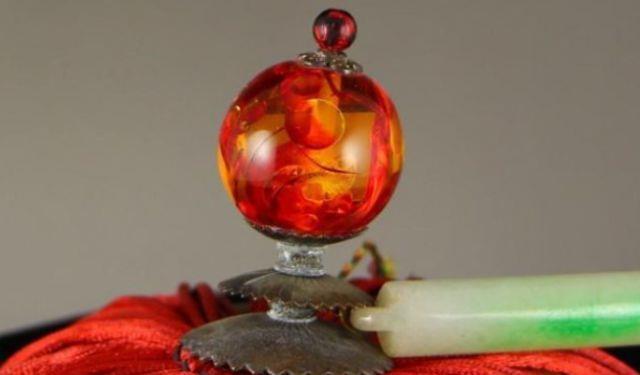 清朝是通过顶戴花翎上的顶珠来区分出官员的品级和地位.