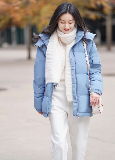 选择这种浅蓝色的羽绒服,看着非常年轻,然后再搭配白色的围巾以及白色