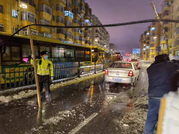 哈爾濱街頭暖心一幕:雨雪交加中,他們撐起一條通行路