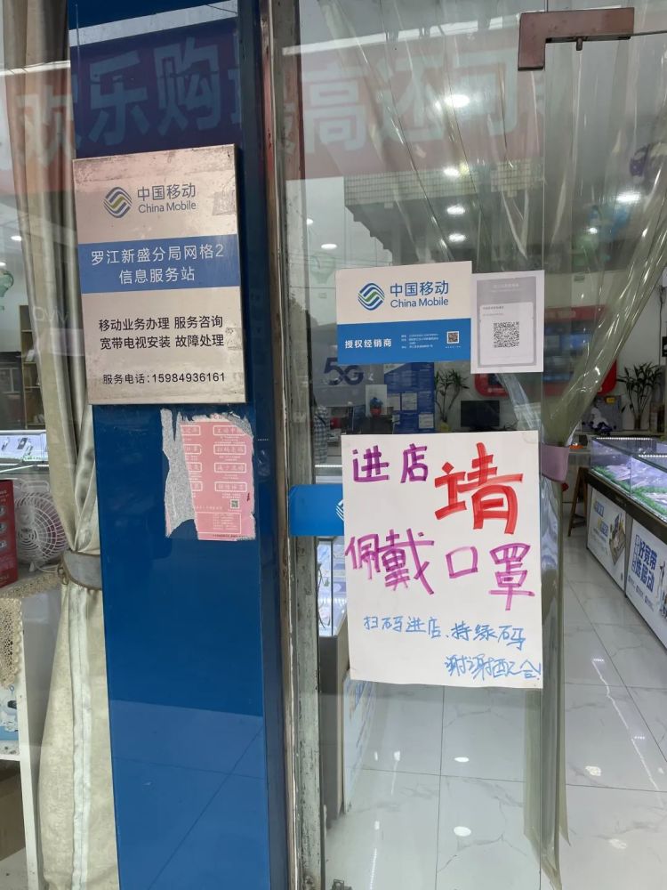 紧挨该超市的一家通信营业厅门口虽有手写的"扫码进店,进店请戴口罩"