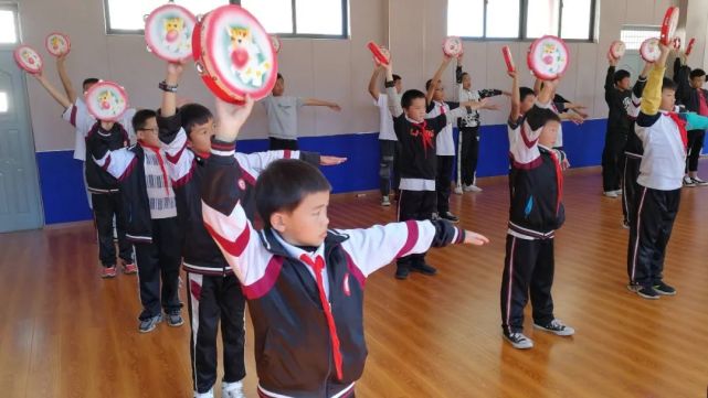 培训现场,孩子们拿着"霸王鞭","八角鼓"跟着节奏,不时转身,踢腿,敲击