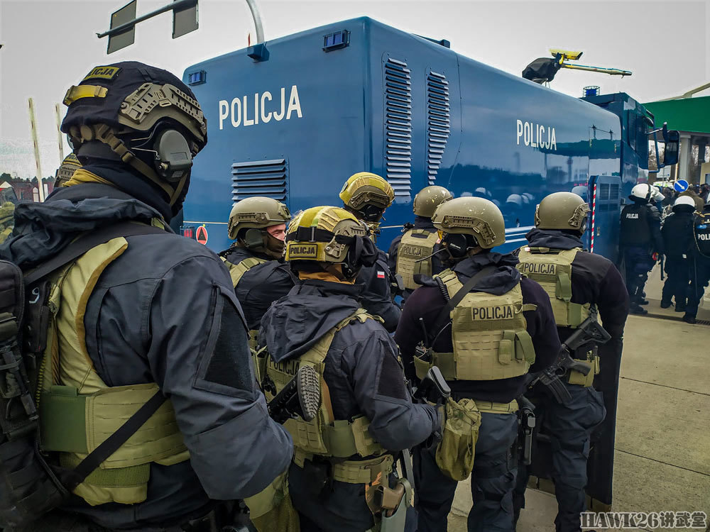 站停着波兰警方的水炮车,特警前方还有戴着白色头盔的波兰防暴警察