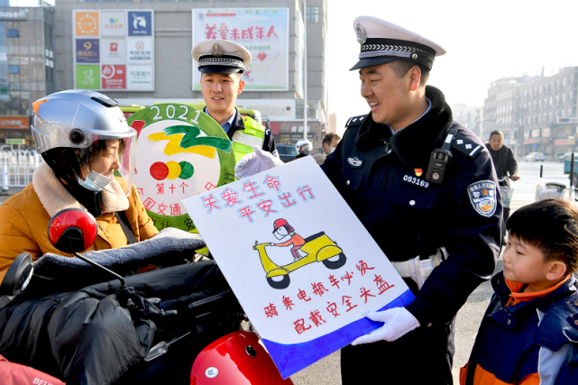 安全文明出行"迎"全国交通安全日"主题宣传活动,民警通过制作宣传图版