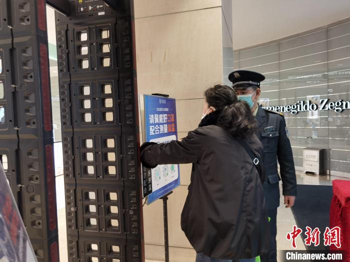 图为市民测温亮码后进商场. 徐雪 摄
