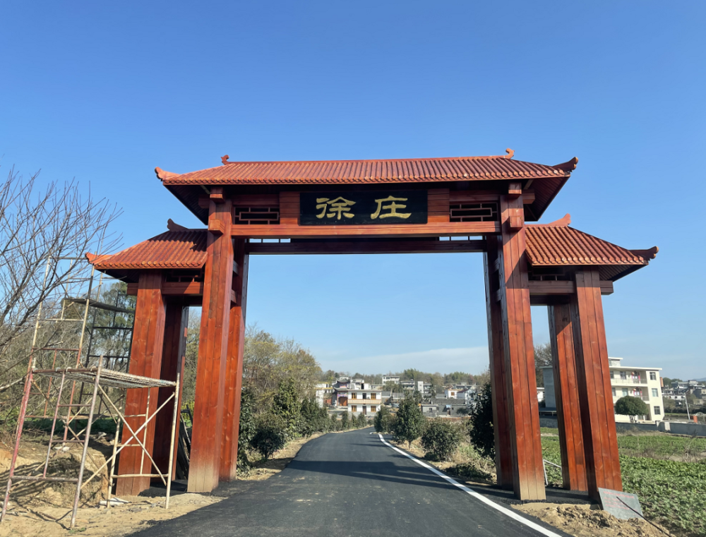 黑底金字的徐庄二字简约大气一座古朴的红色木质门头来到村口……一幅