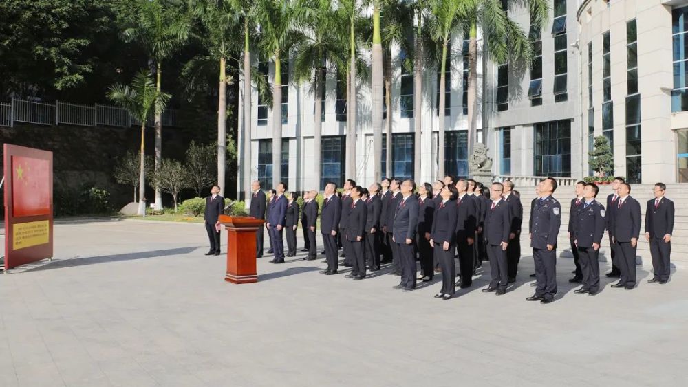 許志鵬檢察長左手撫按憲法,右手舉拳,帶領全體幹警面向國旗進行忠於