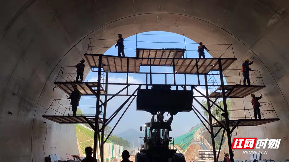 颜永成和同事们在隧道拱顶施工.