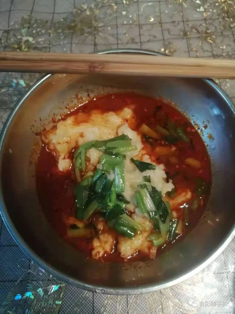 然后加入酸汤,夹一筷子油泼辣子,顺汤搅匀就从碗边开始夹起一块,汤里