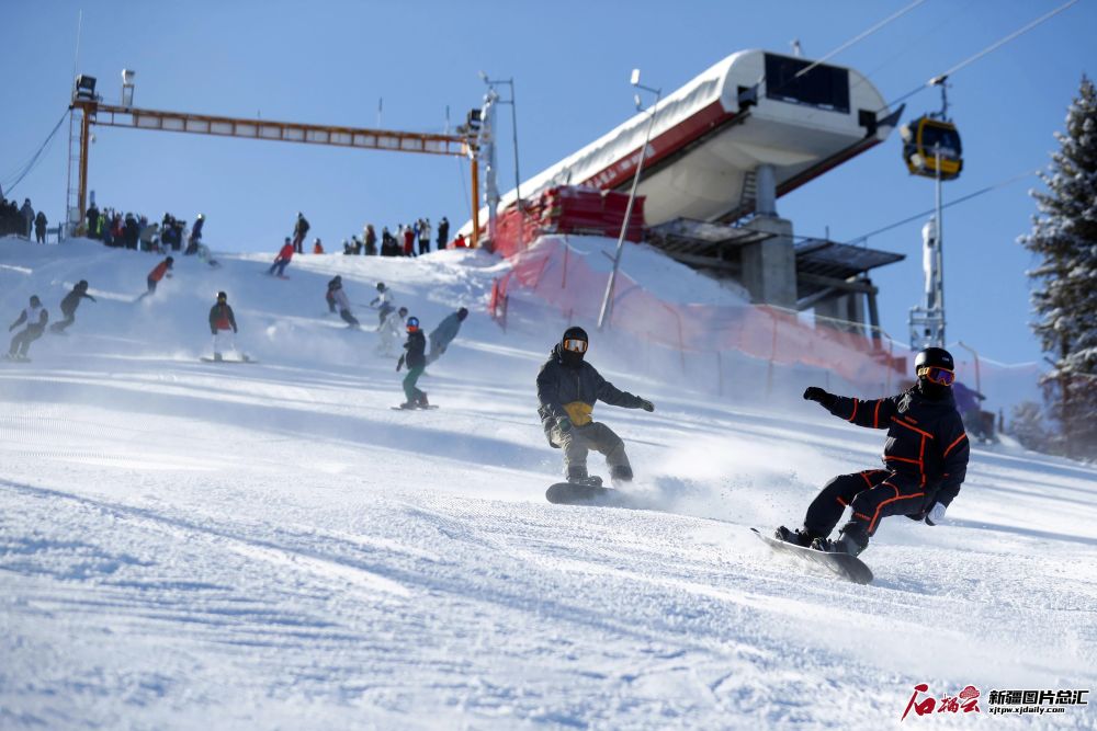 雪友们在新疆丝绸之路国际度假区滑雪场艾文大道起点飞驰而下(11月20