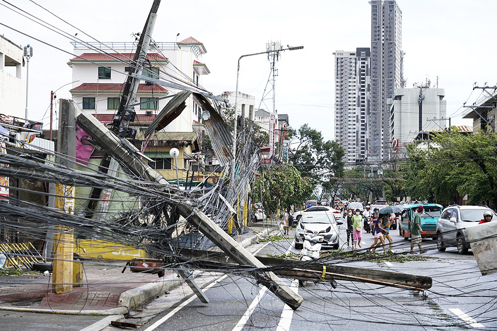 12月18日,菲律宾宿雾塔里萨伊,一名居民在抢救被台风破坏的房屋.