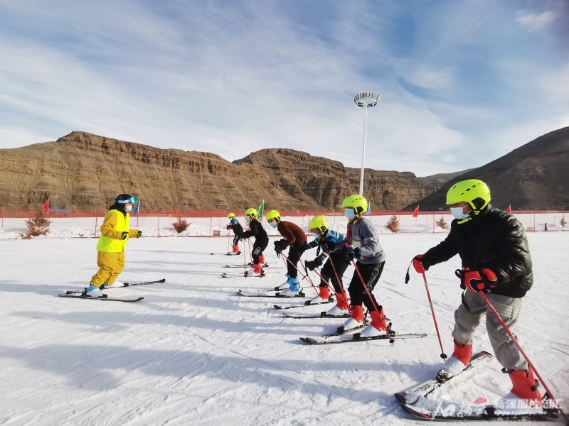 12月20日,在乌什县泉域星空国际滑雪场,乌什县国庆中学学生跟着教练