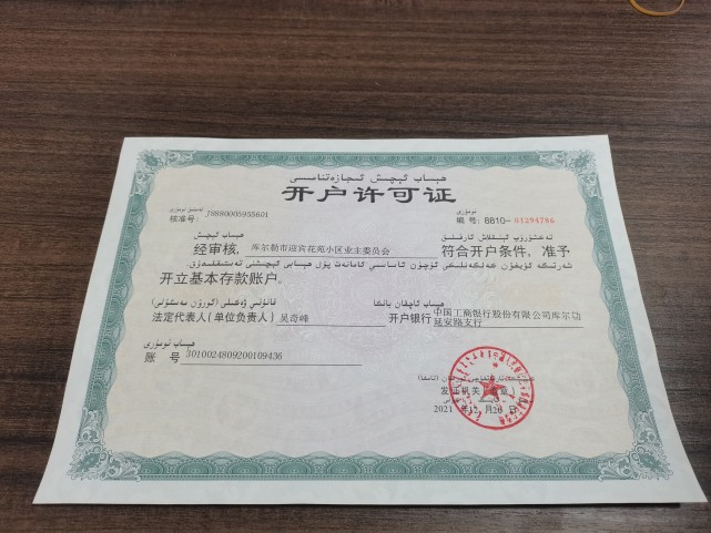 业委会主任吴奇峰正拿着银行开户许可证给业委会的成员和小区业主传阅