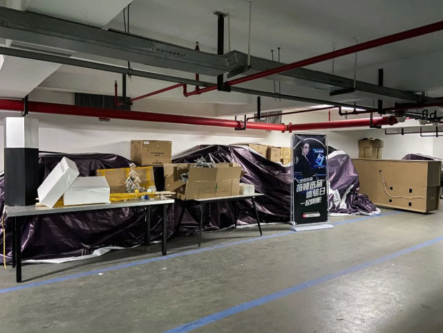 谦寻公司停车库堆放的纸箱及薇娅海报