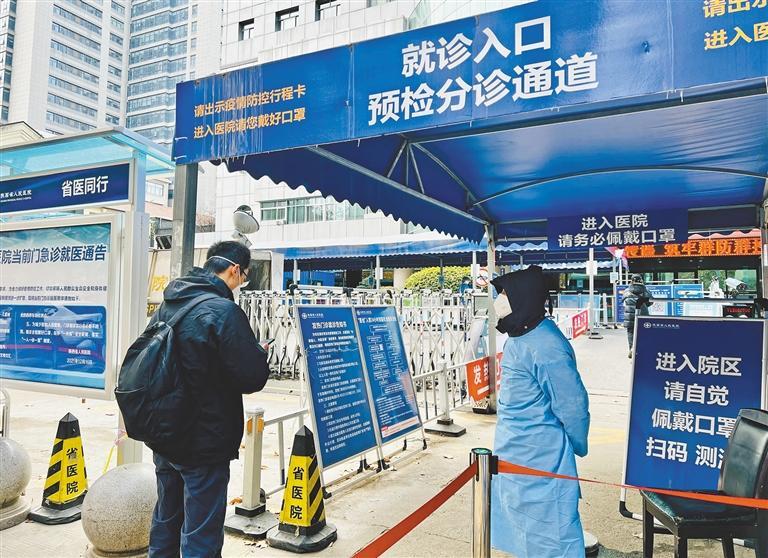 12月26日,陕西省人民医院预检分诊通道入口,就诊患者在工作人员的引导