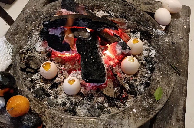 四川一居民在炭火炉边烤鸡蛋刚放调料下一秒烤蛋变炸蛋