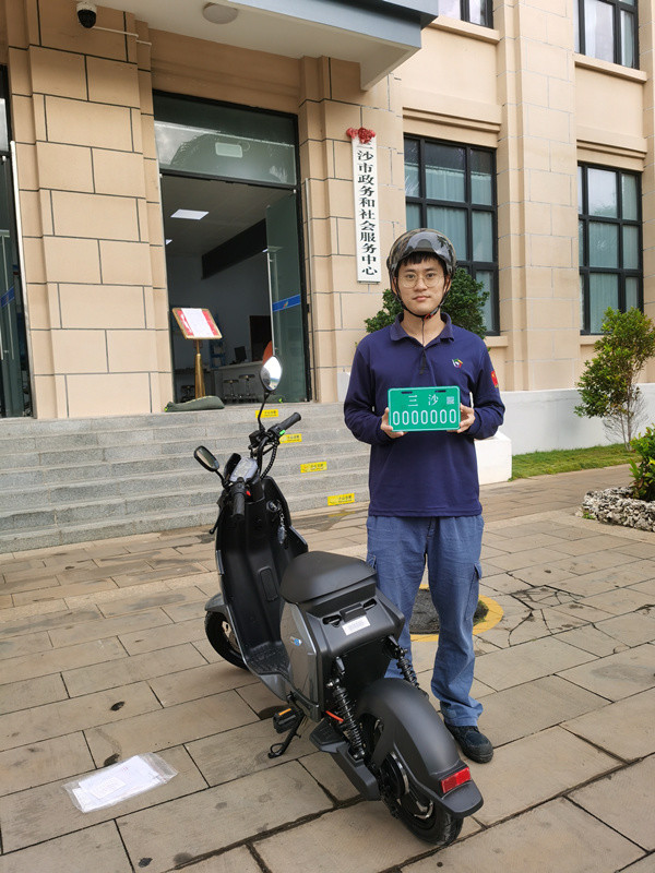 审核材料,并热情地向群众介绍电动自行车登记上牌流程,积极为群众答疑