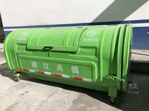 记者看见,此次新采购来的垃圾箱和垃圾清运车整齐的堆放在镇江关镇