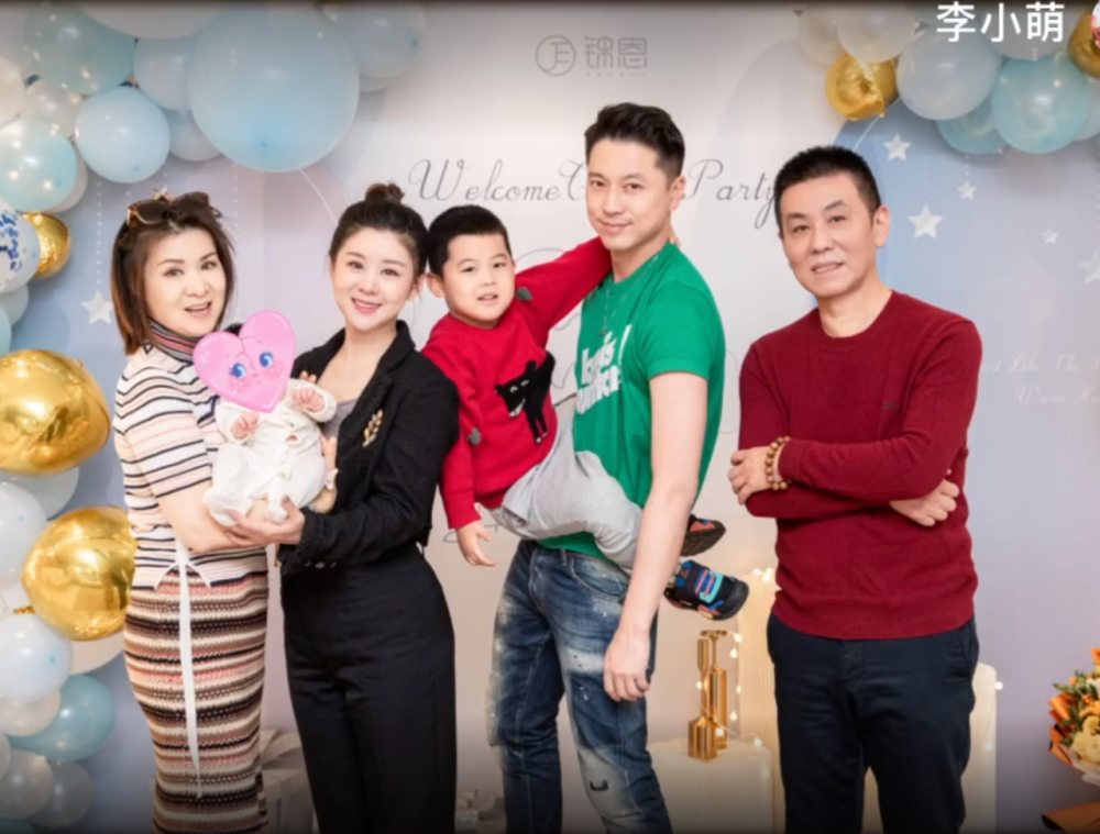 王雷李小萌一家四口一起拍摄全家福,夫妻俩一人抱一娃,笑容灿烂,画面