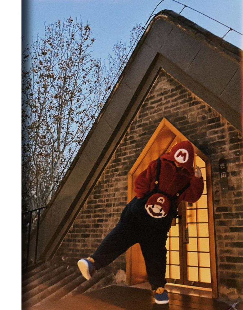 许君聪穿着一袭古装长袍,头戴乌纱,手持折扇,可爱的面孔上还化了浓妆