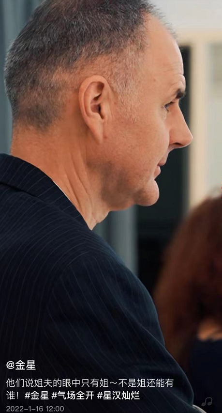 视频中,陪着老婆工作的汉斯站在人群中,眼神温柔地注视着忙工作的老婆