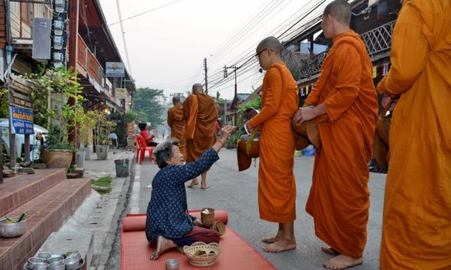 老和尚走前,小沙弥殿后,每每经过布施信众,都会停下身来念经祈福,并