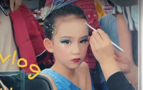 视频中的她正在化妆,蓝色眼影加黑色眼线跟蓝色演出服十分和谐.