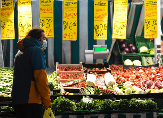 1月19日,在德国法兰克福,人们在一处农贸市场选购食物.