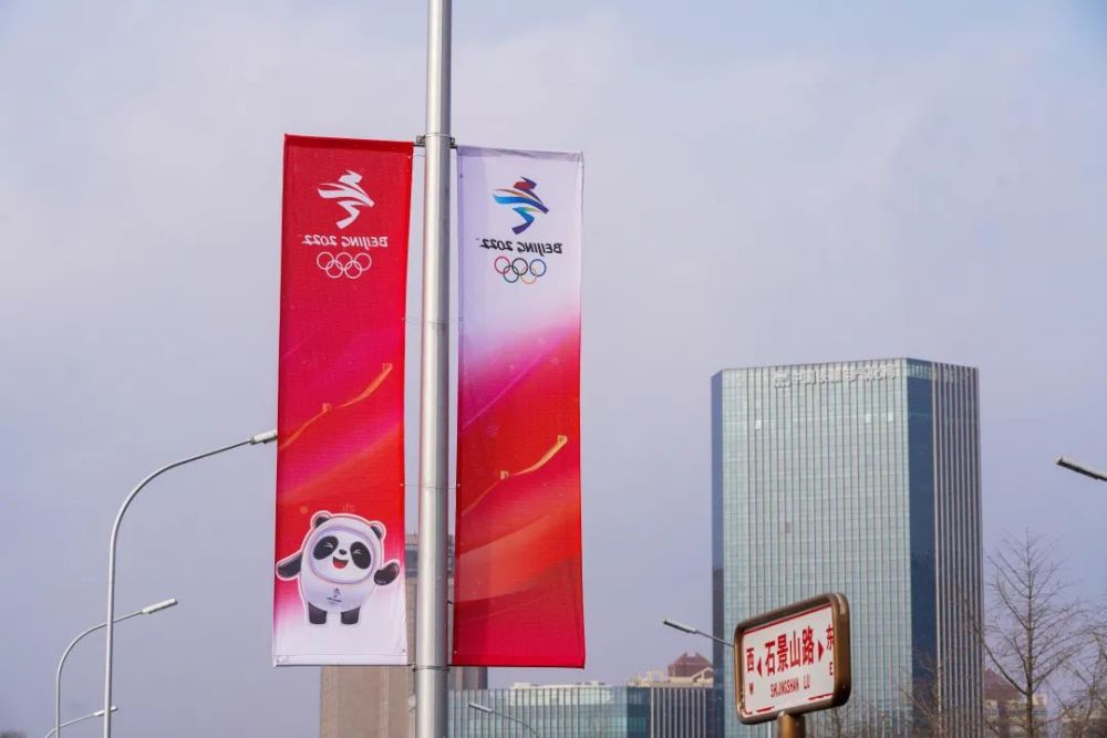 北京冬奥和冬残奥道旗,路标在雪中十分醒目△环卫工人清扫道路积雪