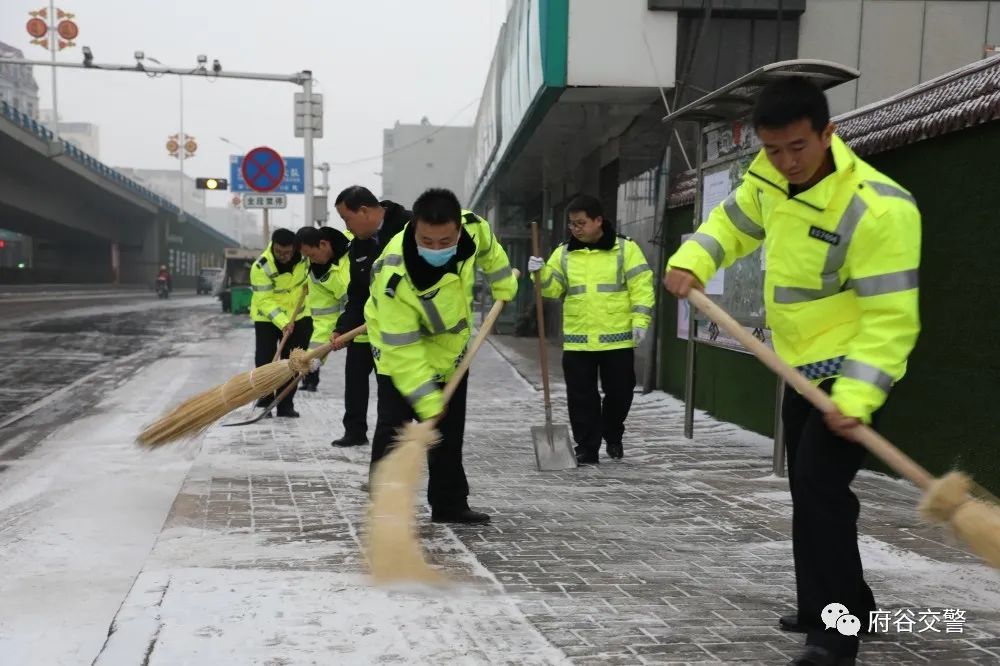 府谷民警保障市民出行安全白雪茫茫路湿滑街头扫雪暖人心