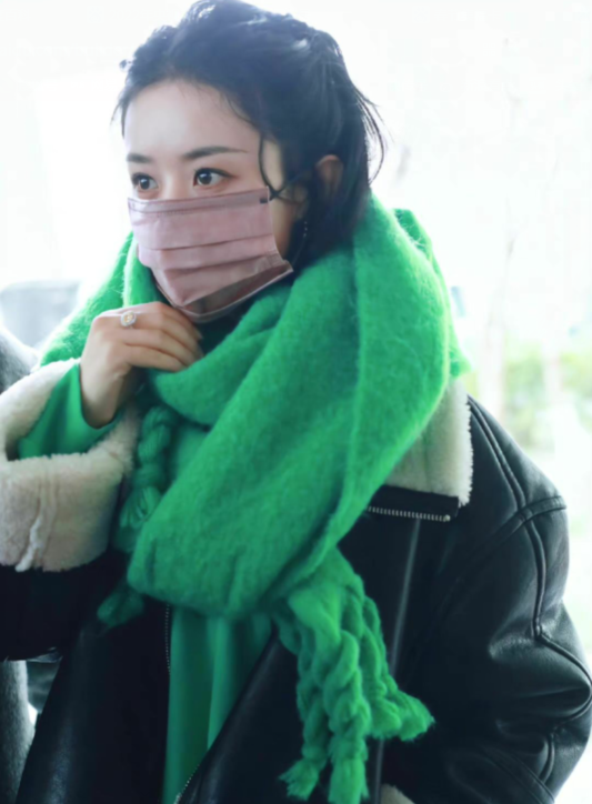 身穿黑色皮衣外套搭配绿色帽衫卫衣和绿色大围巾,十分亮眼,赵丽颖虽说