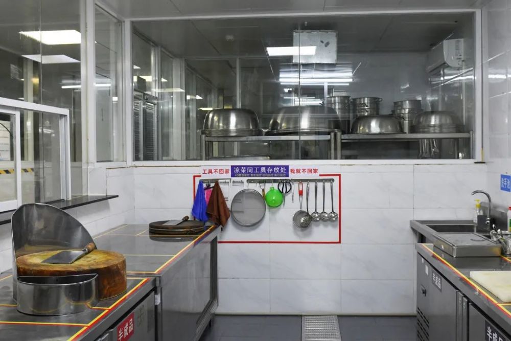 来到餐具洗消间,记者看到,厨房工作人员身着工作服,规范佩戴口罩和