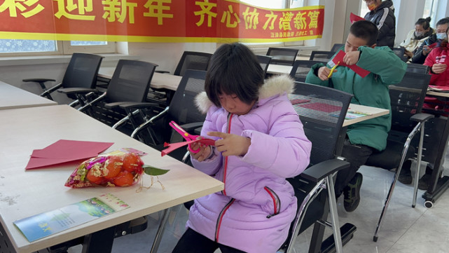 活動現場,社工人員帶領孩子們一起做歌曲《新年好》手勢舞,為他們講解