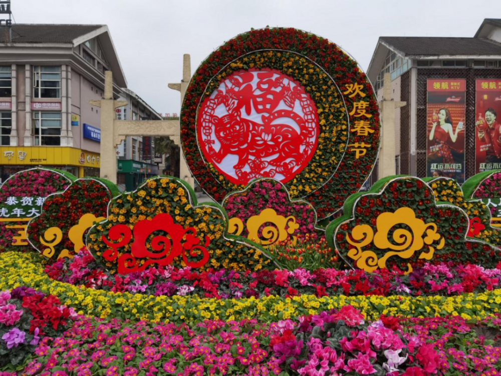 三贤文化公园晨风广场运用"春"字鲜花造型,家,春联,灯笼等元素体现